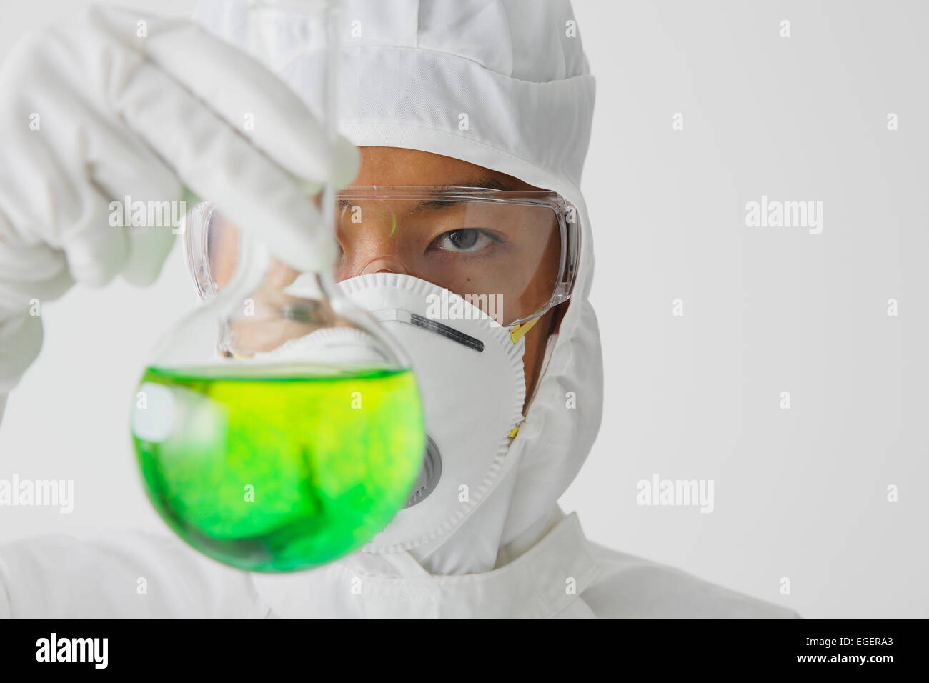 Joven japonés en un traje protector que trabajan con productos químicos Foto de stock