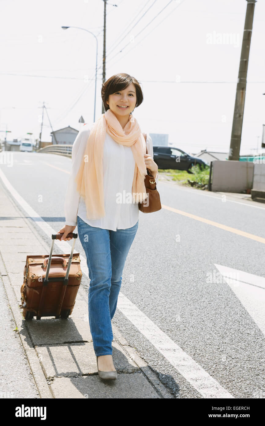 Jovencita japonesa caminando con maleta Fotografía de stock - Alamy