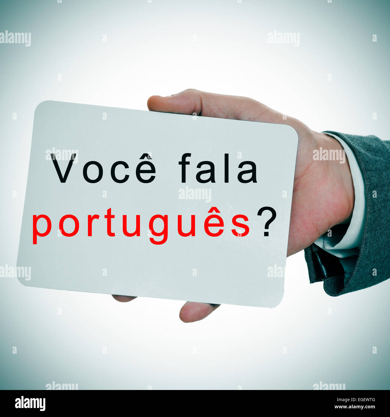 Manos del hombre mostrando un cartel con la frase voce fala portugues? ¿Hablan portugués escrito en él Foto de stock
