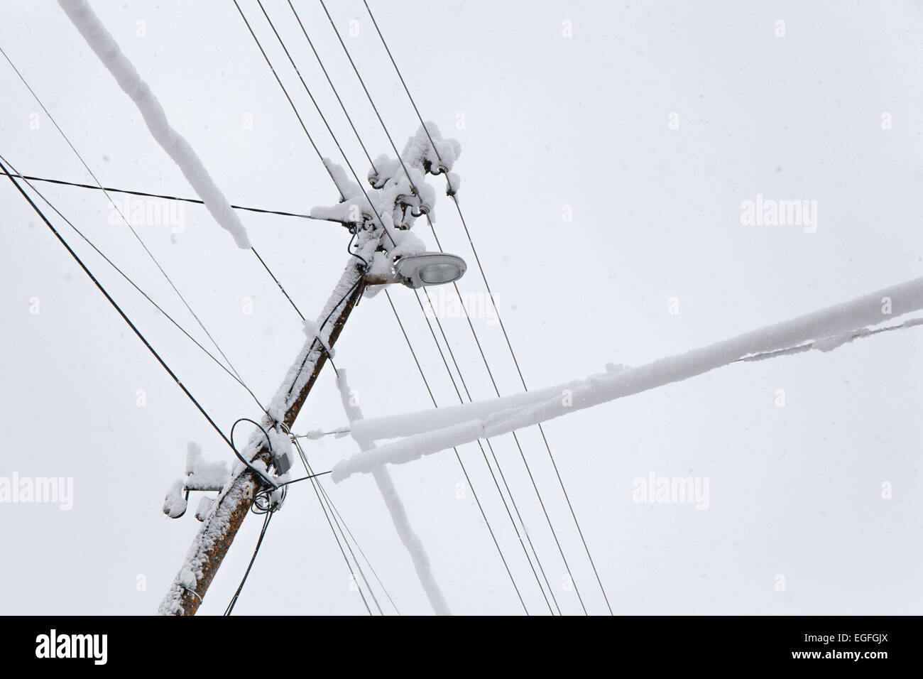 La caída de nieve sobre un poste eléctrico congelada en un frío día de invierno. Foto de stock