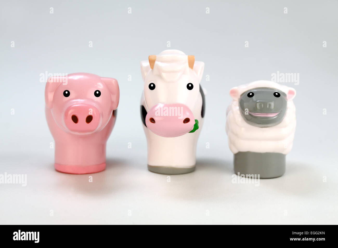 Toy criaderos de cerdos, vacas y ovejas sobre fondo blanco. Foto de stock