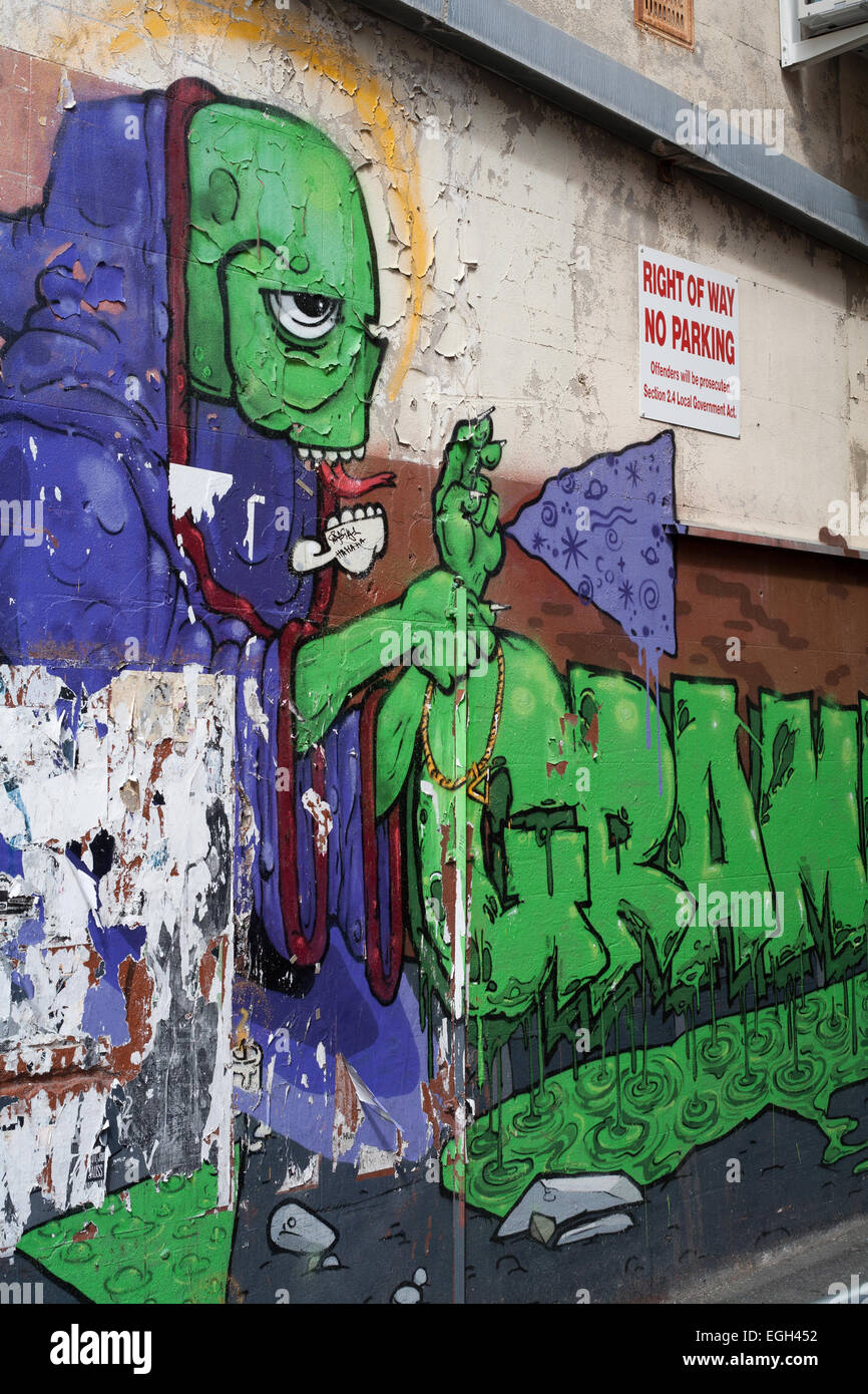 Graffiti imagen de un humanoide en un callejón junto a una pared sin señal de estacionamiento en la ciudad de Perth, Australia Occidental. Foto de stock