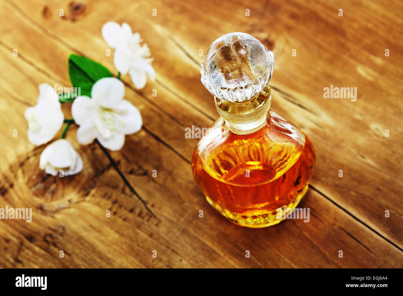 Antiguo perfume y flores artificiales de jazmín. Profundidad de campo. Foto de stock