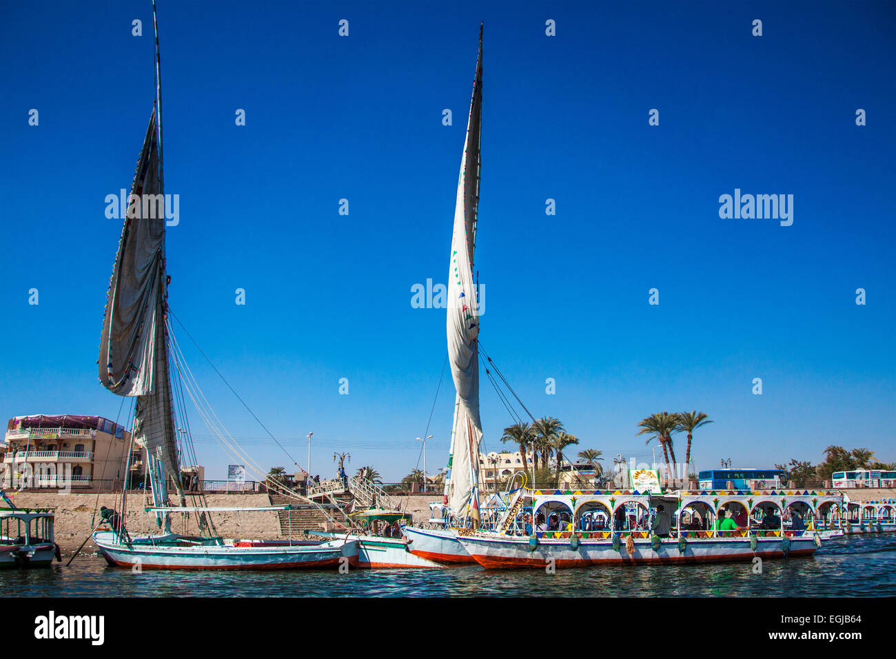 Coloridos barcos y transbordadores feluchos amarrado en la Ribera Occidental esperando para llevar a los turistas a través del Nilo hasta Luxor. Foto de stock