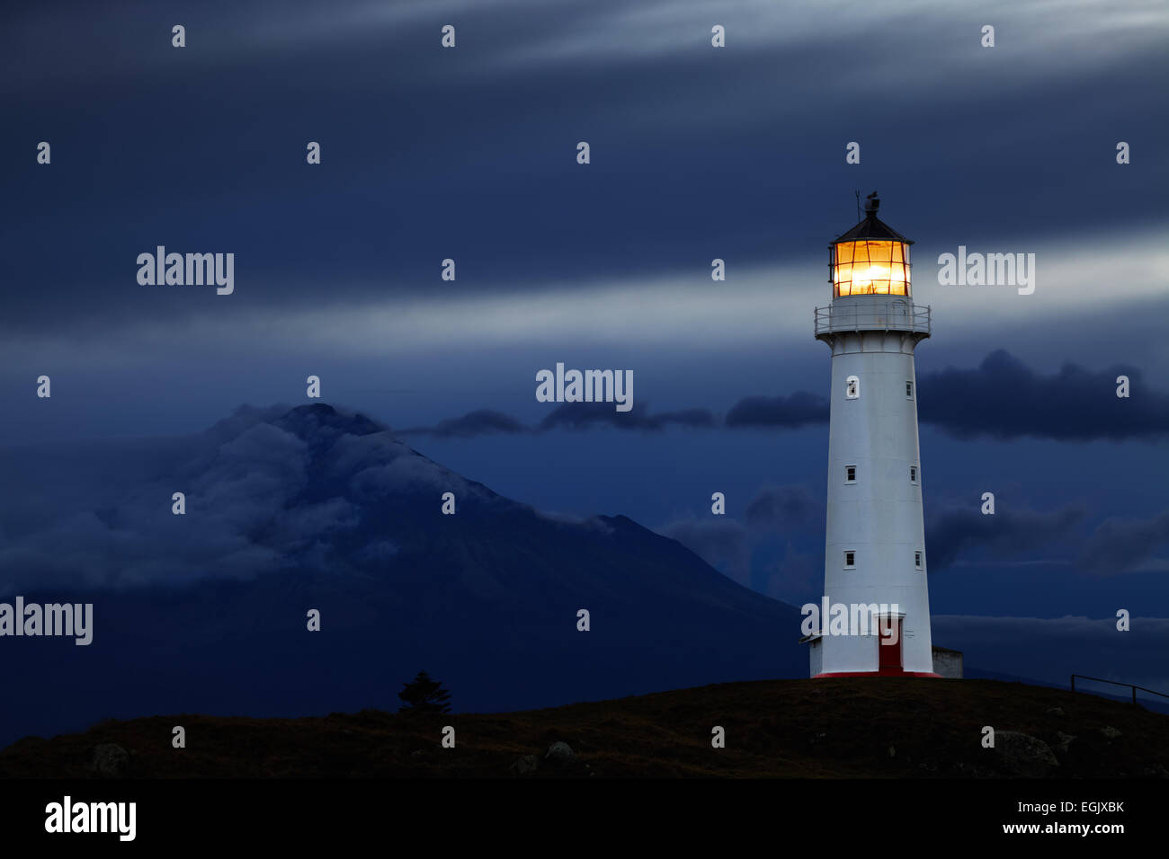 Faro de Cabo Egmont y monte Taranaki sobre antecedentes, Nueva Zelanda Foto de stock