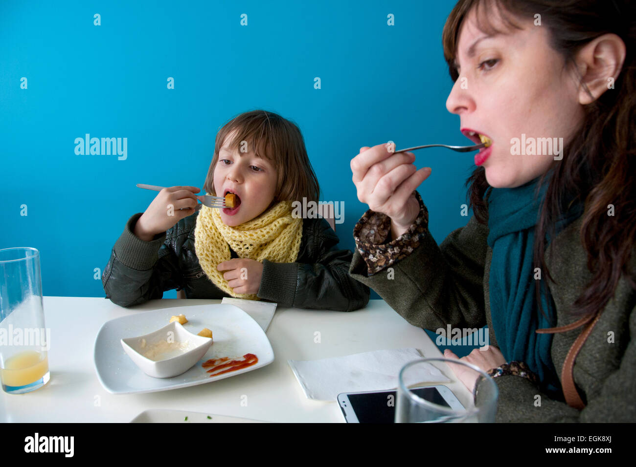 43 años de edad y madre española hijo de seis años comiendo 'patatas bravas', Barcelona, España. Foto de stock