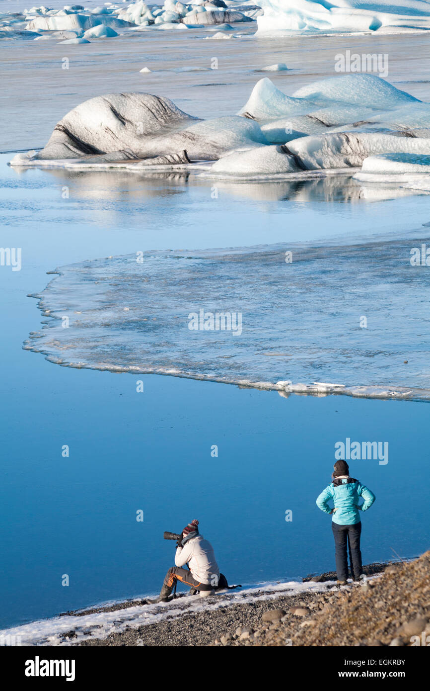 Fotógrafo que toma fotos del impresionante paisaje de la laguna glacial de Jokulsarlon, en el borde del Parque Nacional de Vatnajokull, Islandia, en febrero Foto de stock