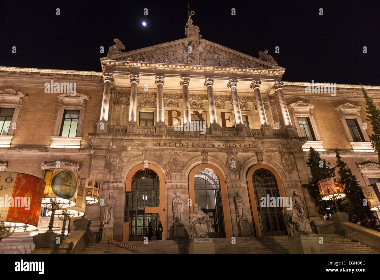 Las escaleras y la entrada principal con monumentos de la Biblioteca Nacional de España (Biblioteca Nacional de España) por la noche. Foto de stock