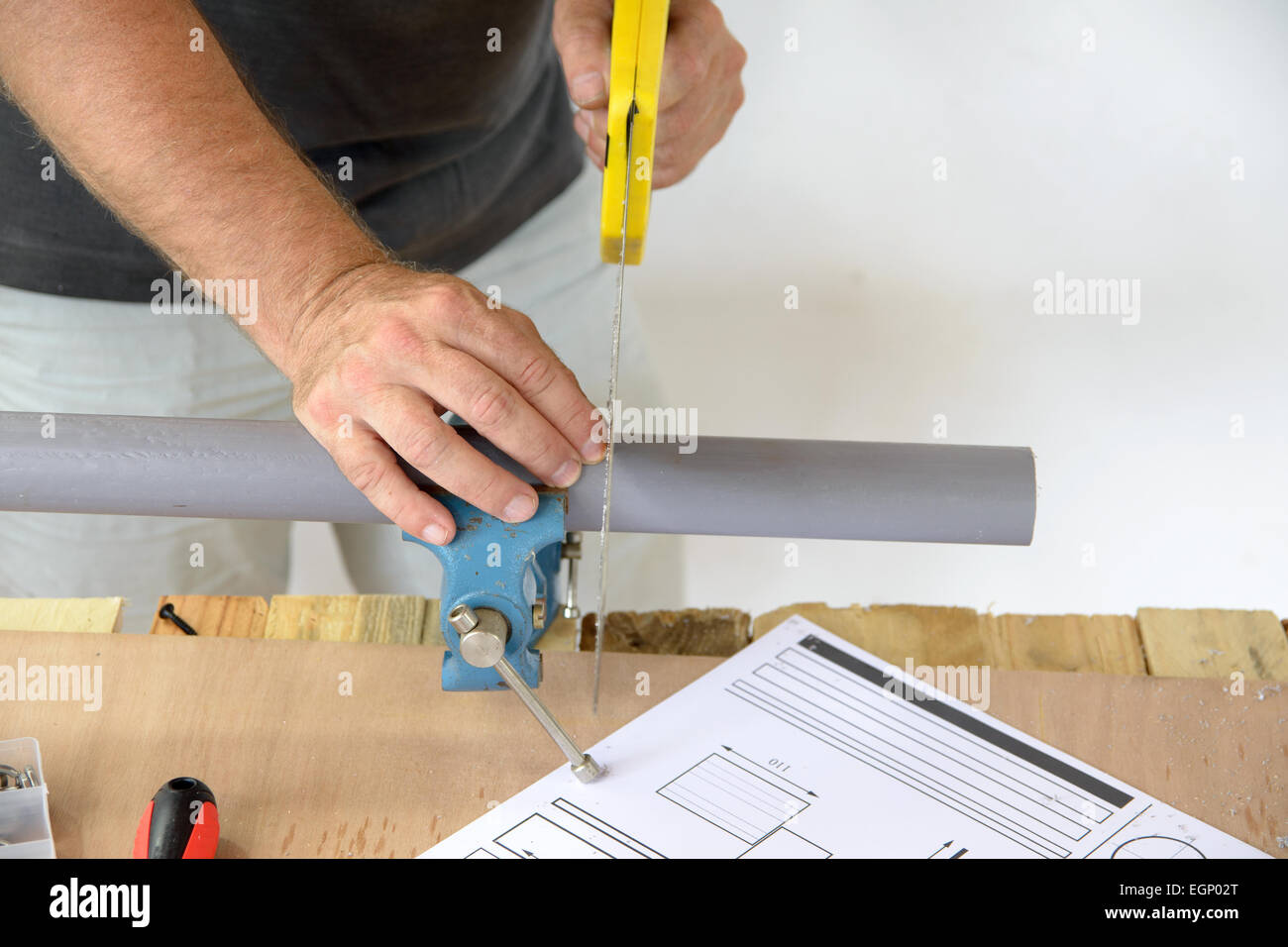 Un fontanero cortar el tubo de PVC con sierra Fotografía de stock - Alamy