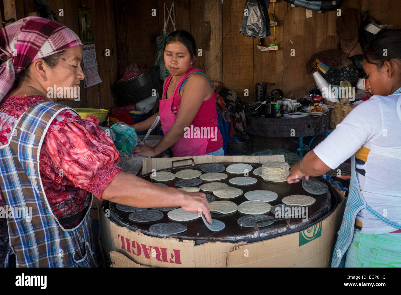 Las mujeres guatemaltecas hacer tortillas frescas en una pequeña panadería en Antigua Fotografía