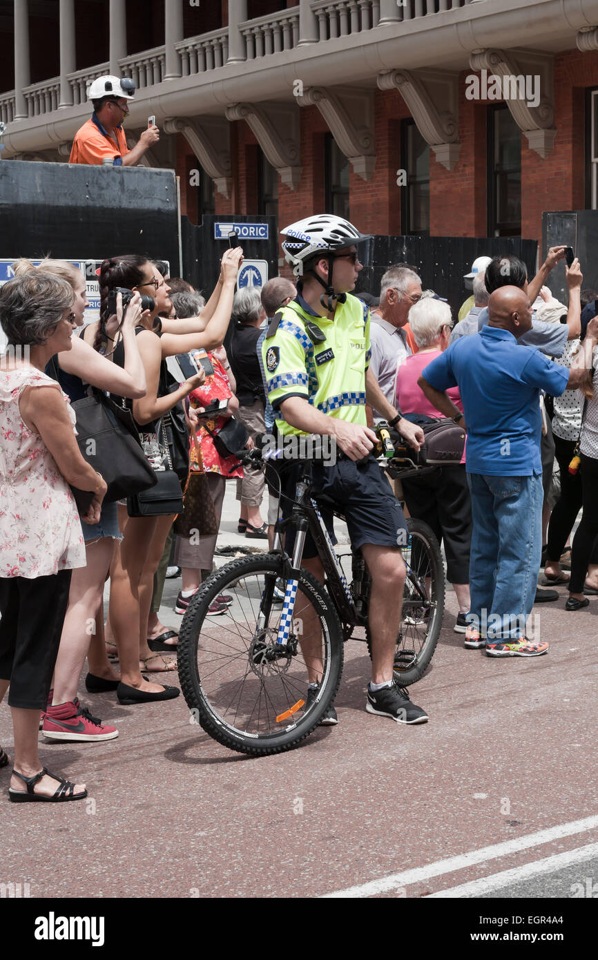 La policía australiana occidental masculina oficial de bicicleta mantener un ojo sobre las actuaciones en un evento público. Foto de stock