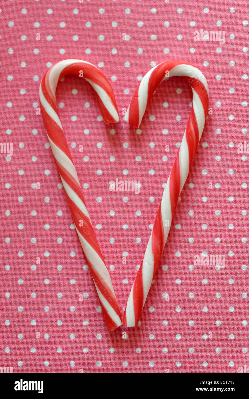 Bastones de caramelo rojo y blanco formando con forma de corazón Foto de stock