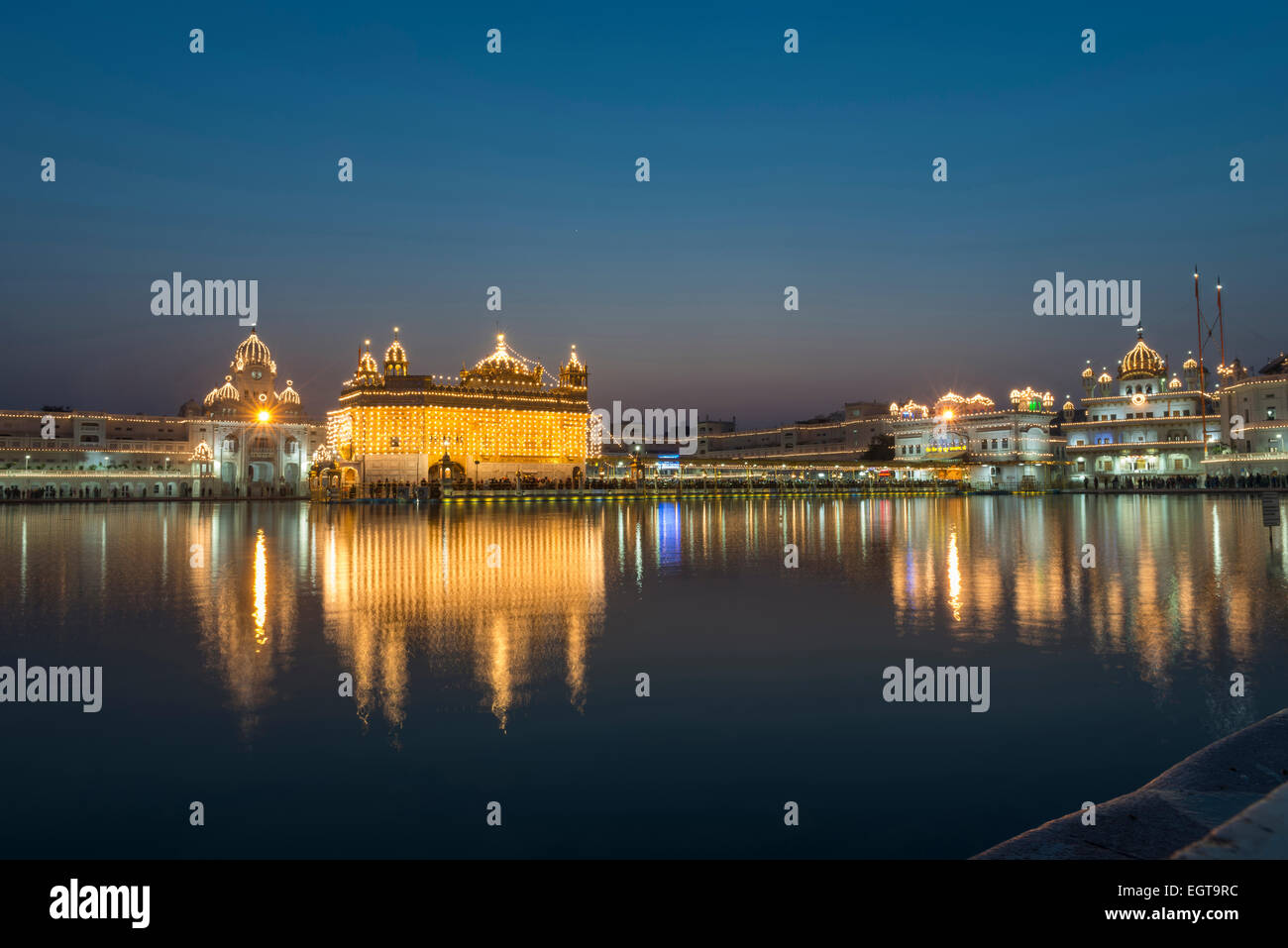 El Templo de Oro de El Harmandir Sahib iluminado al anochecer, en Amritsar, India Foto de stock
