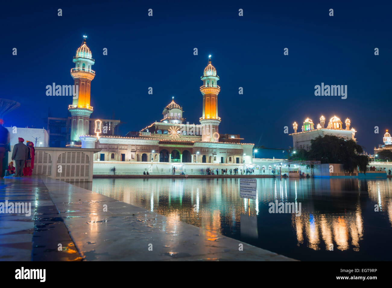 Los minaretes del Templo de Oro iluminado al anochecer, en Amritsar, India Foto de stock