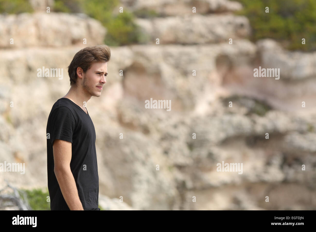 Retrato de un hombre explorando y apartar la mirada en la montaña con un fondo desenfocado Foto de stock