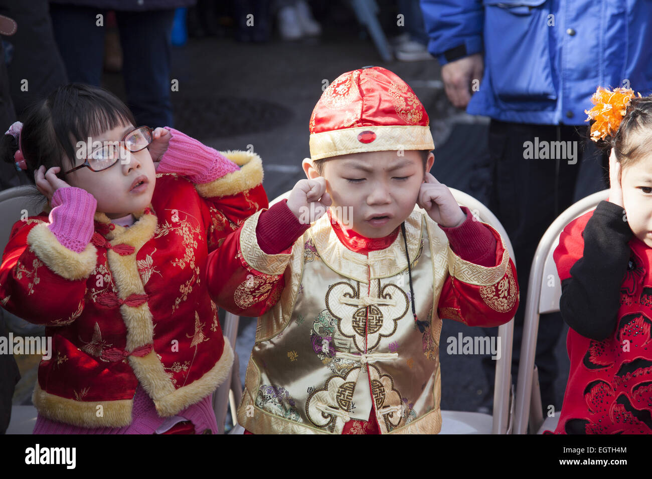 Los niños chinos en disfraces en celebración del Año Nuevo chino mantenga  sus oídos durante la ceremonia petardo muy ruidoso en el Chinatown de  Brooklyn, NY Fotografía de stock - Alamy