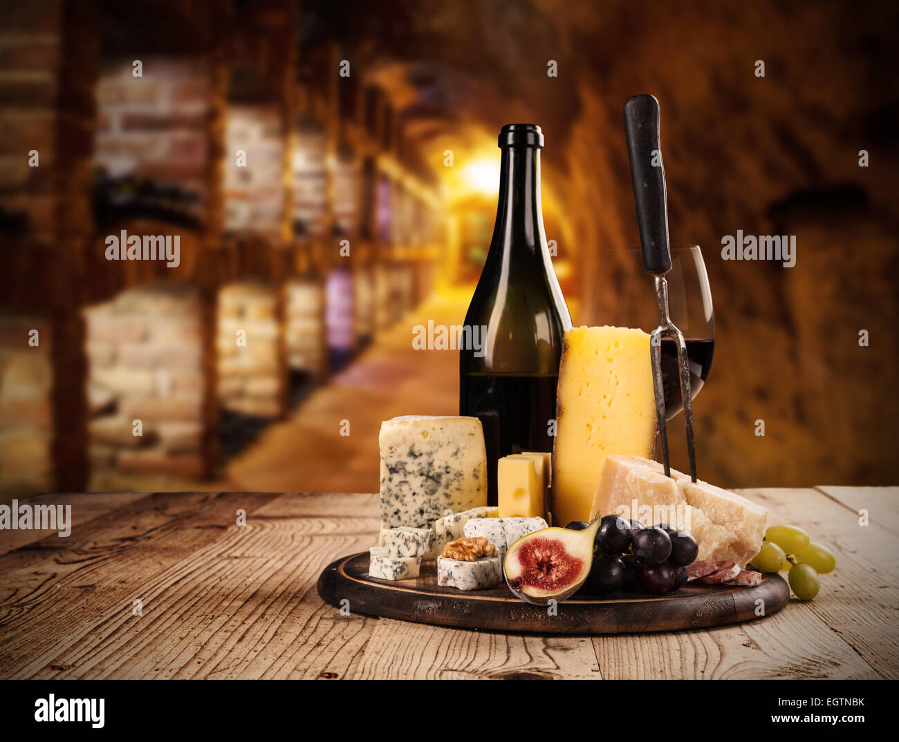 Diversos tipos de queso con vino tinto en bodega Foto de stock