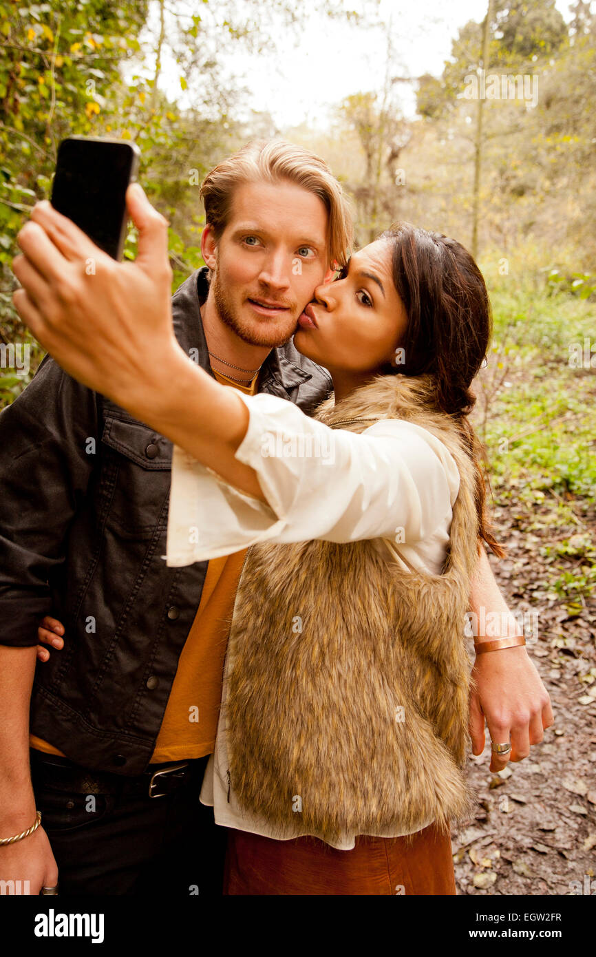 Mujer y hombre teniendo un selfie en el bosque. Foto de stock