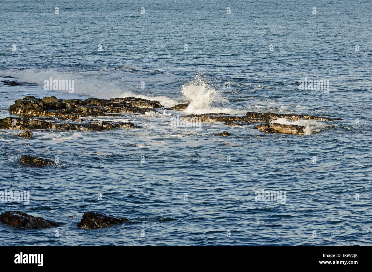 Olas rompiendo sobre las rocas en la costa de Maine. Foto de stock