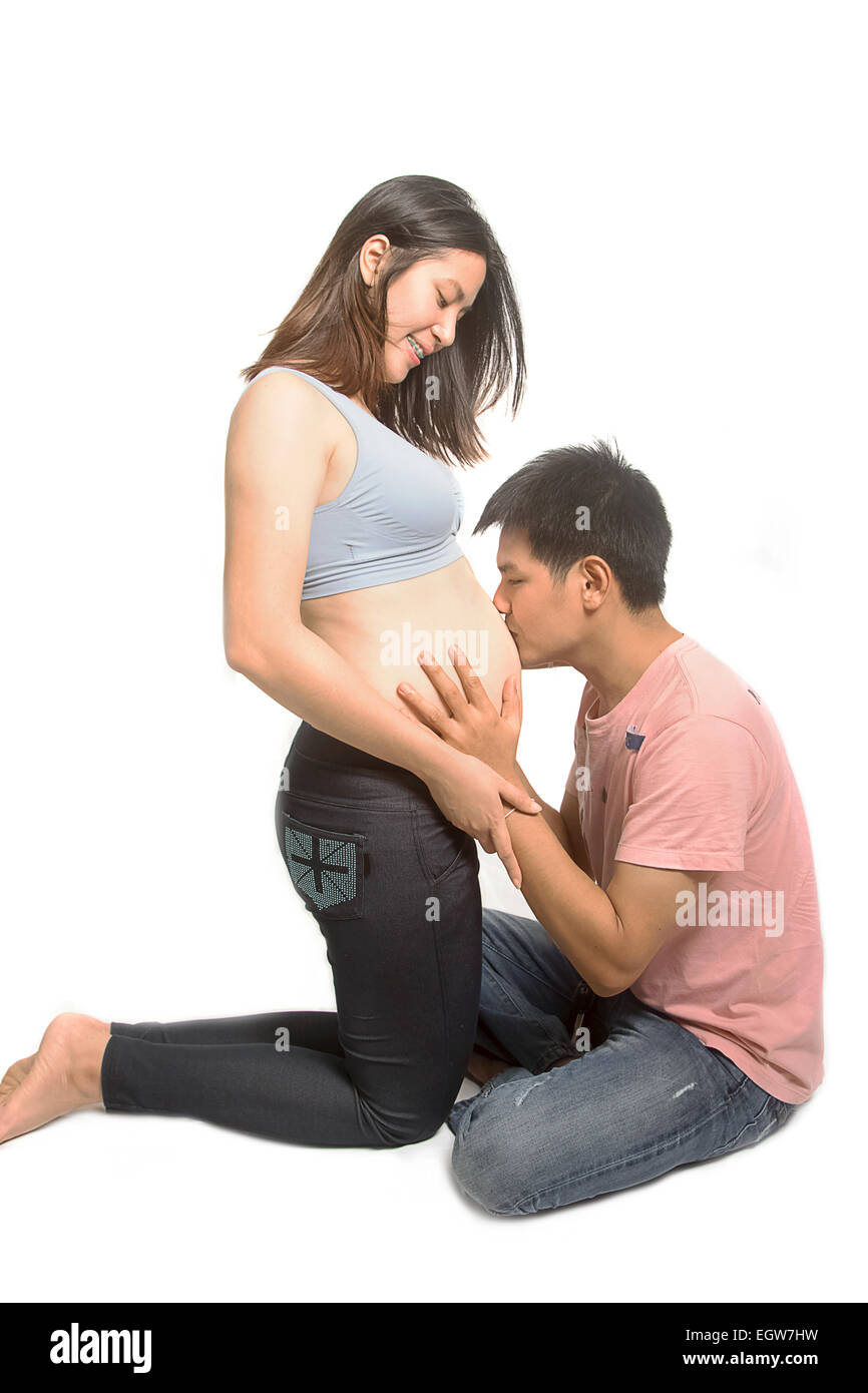 Marido besando a su esposa embarazada vientre Foto de stock