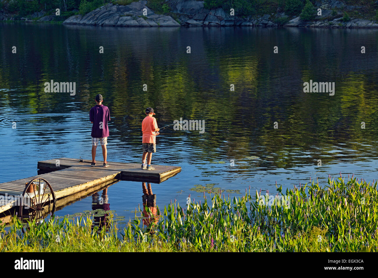 Los muchachos en un muelle de pesca, mayor en Sudbury, Ontario, Canadá Foto de stock