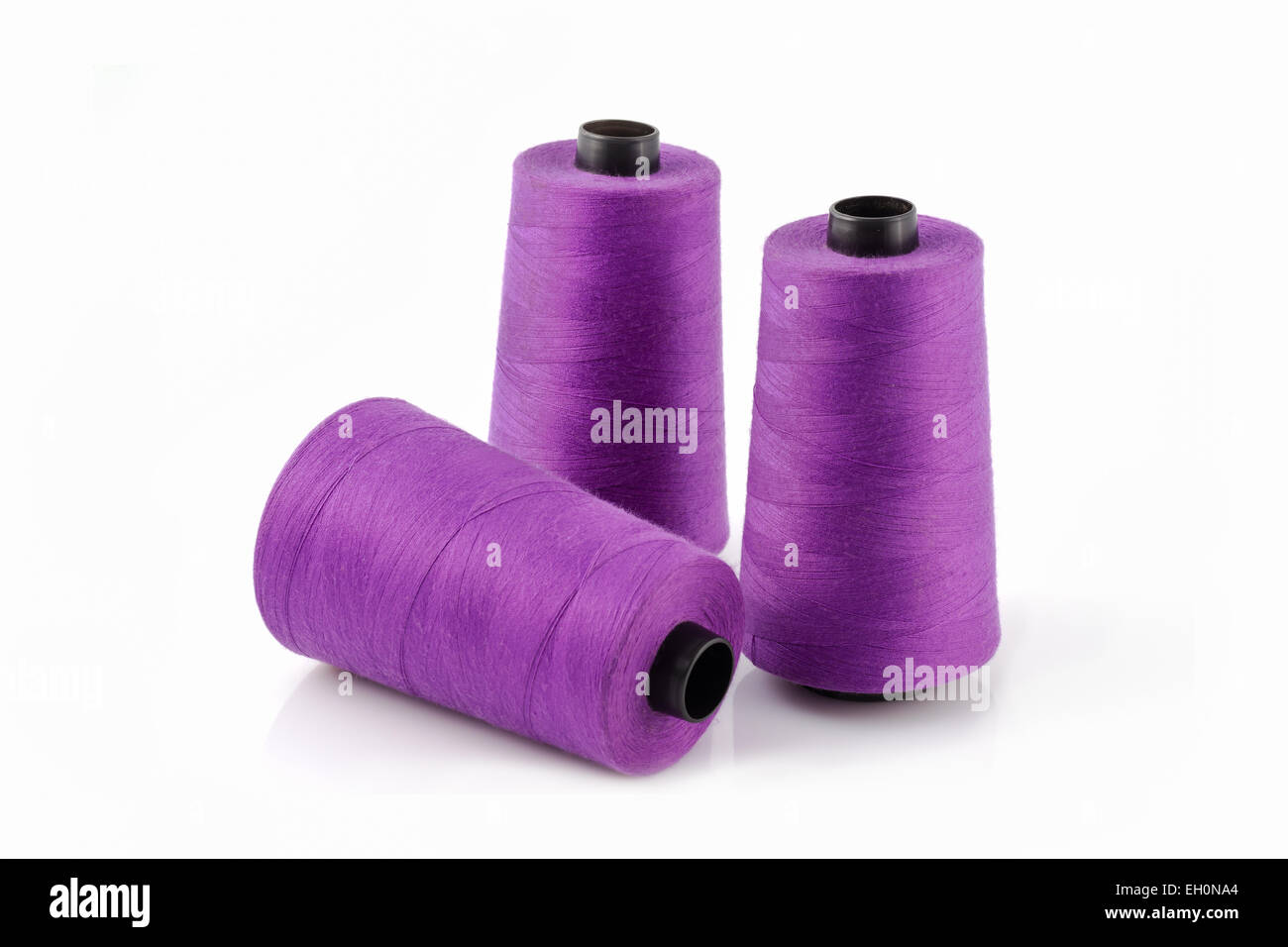 Tres carretes de hilo púrpura Foto de stock
