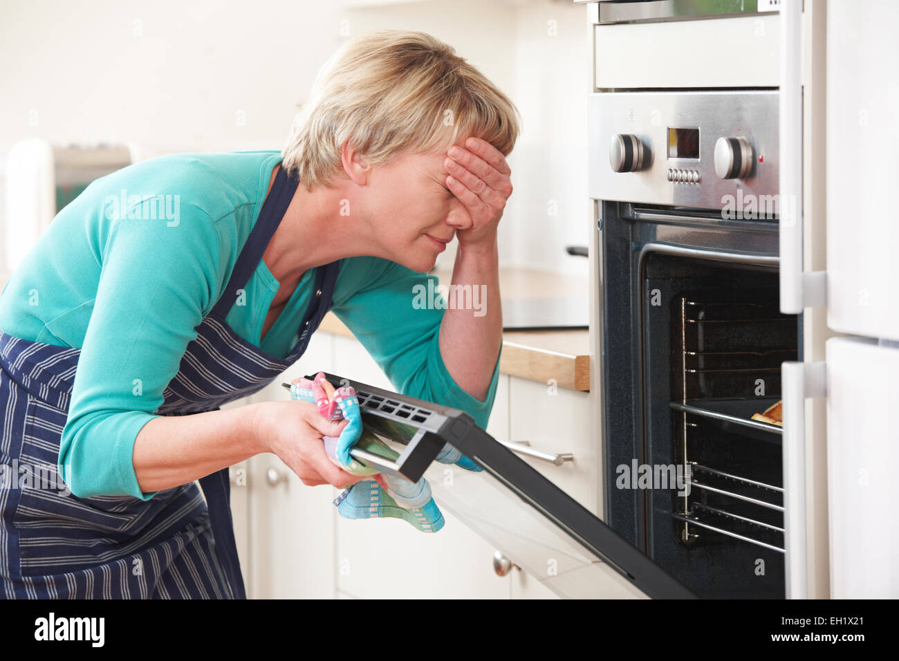 Mujer mirando al horno y tapar los ojos más desastrosa comida Fotografía de  stock - Alamy