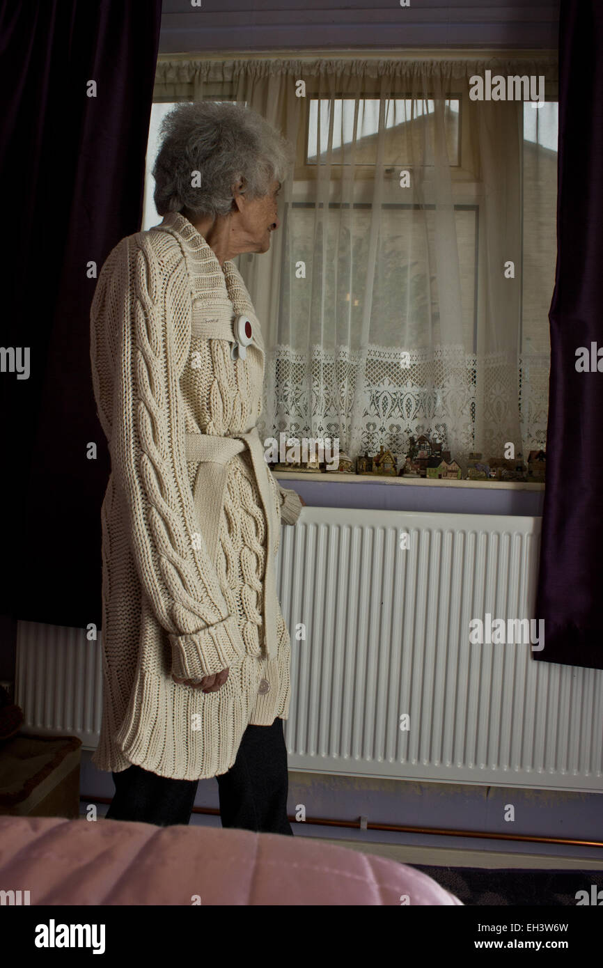 Anciano enfermo de Alzheimer mirando por la ventana de su dormitorio Foto de stock
