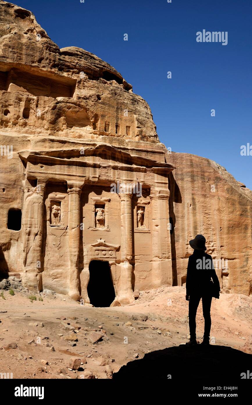 Jordania, Nabataean sitio arqueológico de Petra, catalogado como Patrimonio Mundial por la UNESCO, la silueta de una mujer mirando la fachada de la tumba del soldado romano, esculpido en una roca arenisca Foto de stock