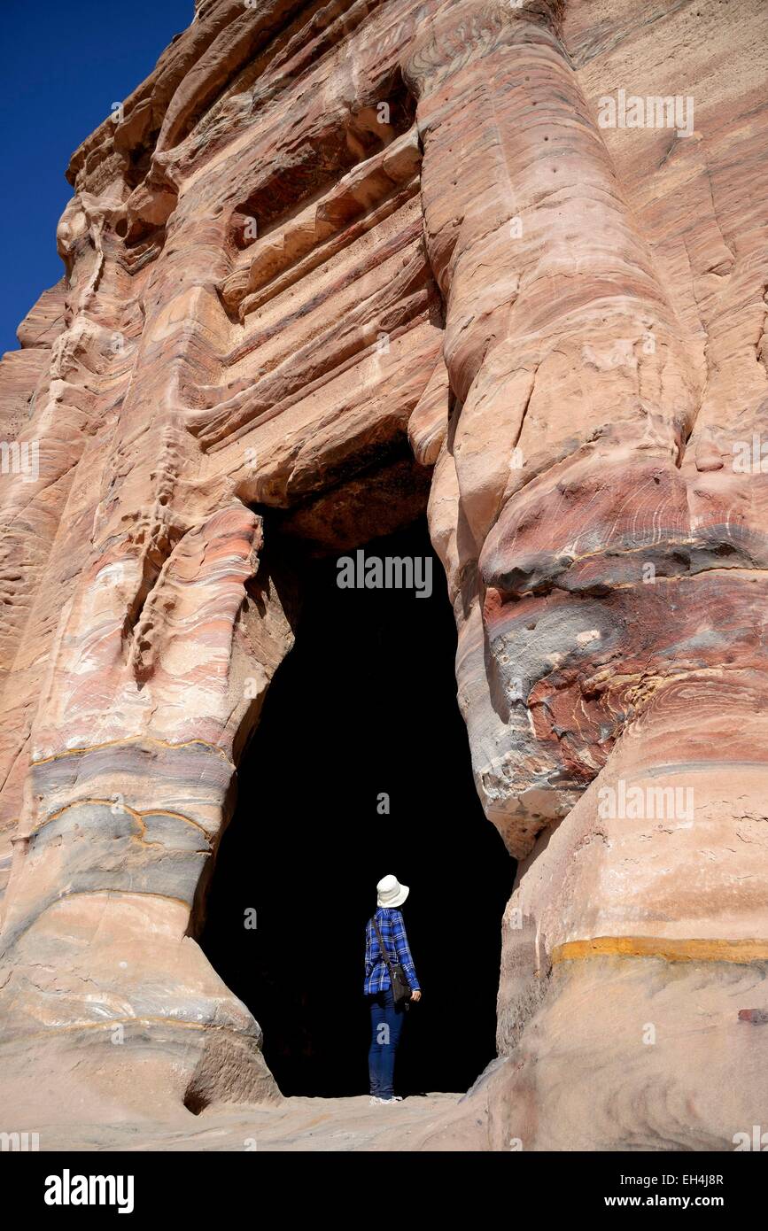 Jordania, Nabataean sitio arqueológico de Petra, catalogada como Patrimonio de la Humanidad por la UNESCO, la mujer a la entrada de una Tumba Real tallada en la montaña Foto de stock