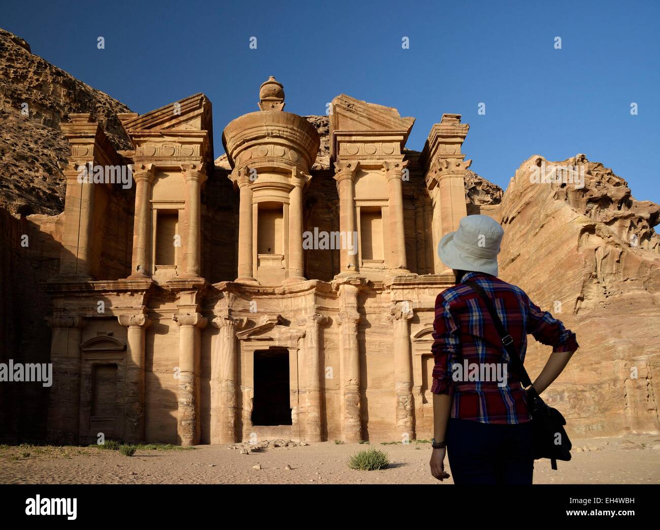Jordania, Nabataean sitio arqueológico de Petra, catalogado como Patrimonio Mundial por la UNESCO, la silueta de una mujer viendo la famosa y tallados de fachada Al Deir (el monasterio), esculpido en una roca arenisca Foto de stock