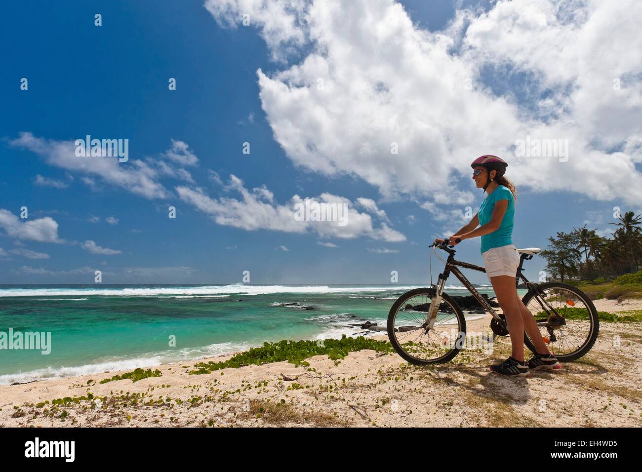 Mauricio, Costa Sur Oeste, distrito de Black River, mujer ciclismo en una playa Foto de stock