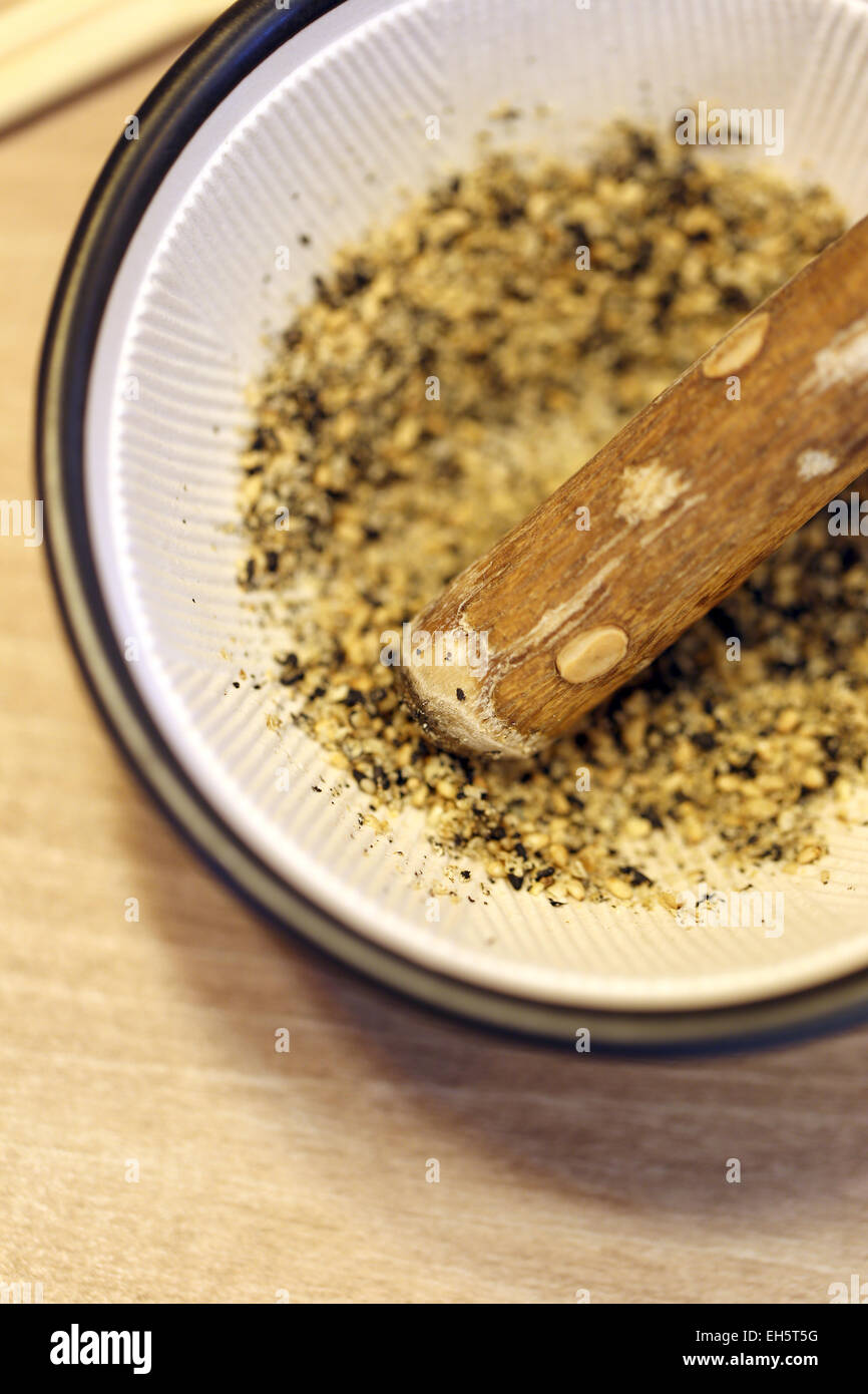 Moliendo las semillas de sésamo en una taza por ingrediente comida japonesa. Foto de stock