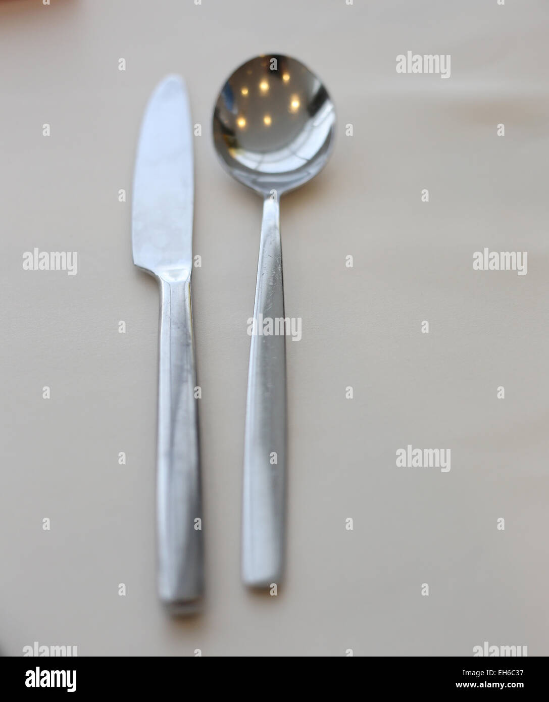 Cucharas y cuchillos se colocan sobre la mesa. Foto de stock