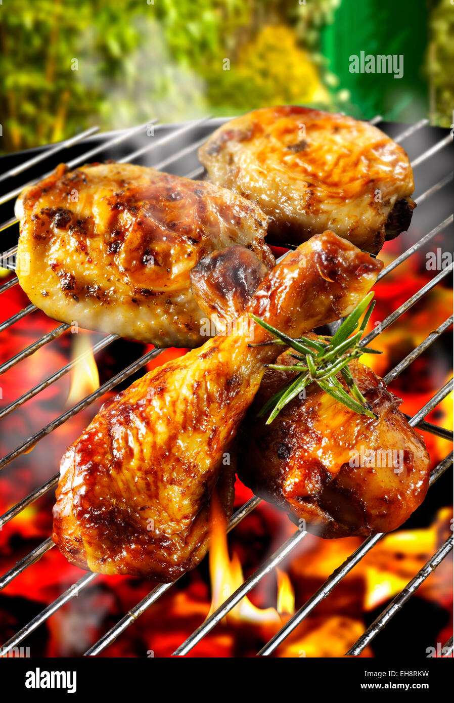 Los pedazos de pollo asado cocinar en una barbacoa en llamas Foto de stock
