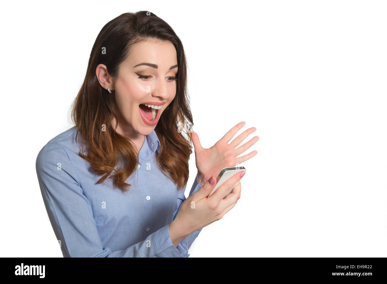 Mujer sosteniendo un teléfono con reacción feliz lectura de mensajes sms aislado sobre fondo blanco. Foto de stock