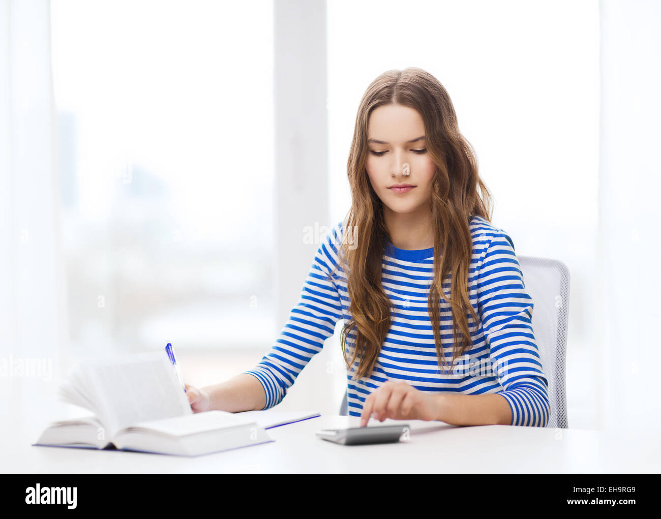 Estudiante chica con libro, calculadora y bloc de notas Foto de stock