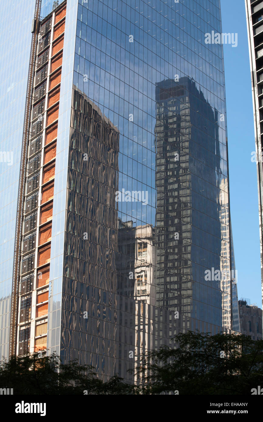 Los reflejos en el cristal de un edificio de oficinas cerca del World Trade Center, el distrito financiero de Manhattan, Nueva York, EE.UU. Foto de stock