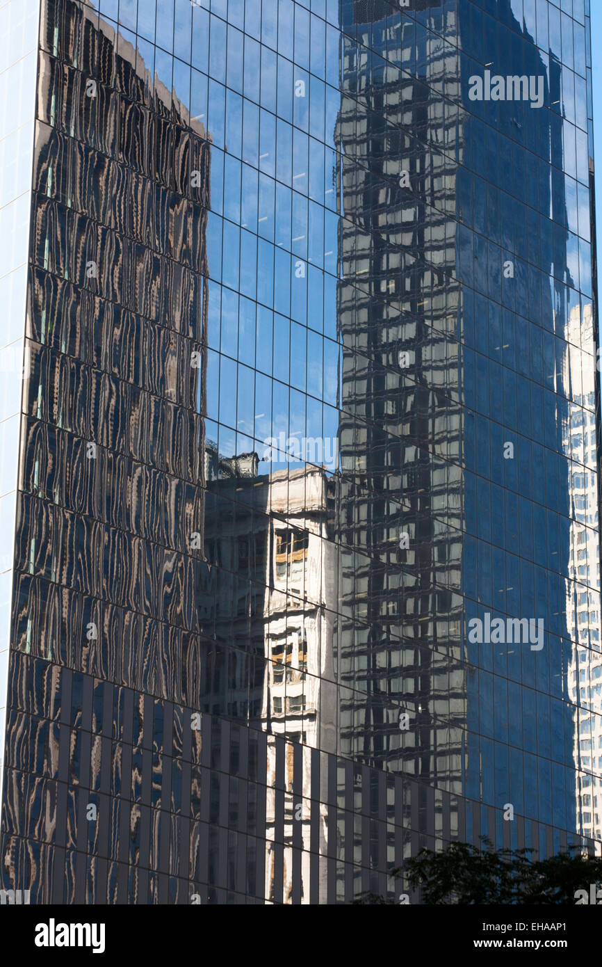 Los reflejos en el cristal de un edificio de oficinas cerca del World Trade Center, el distrito financiero de Manhattan, Nueva York, EE.UU. Foto de stock