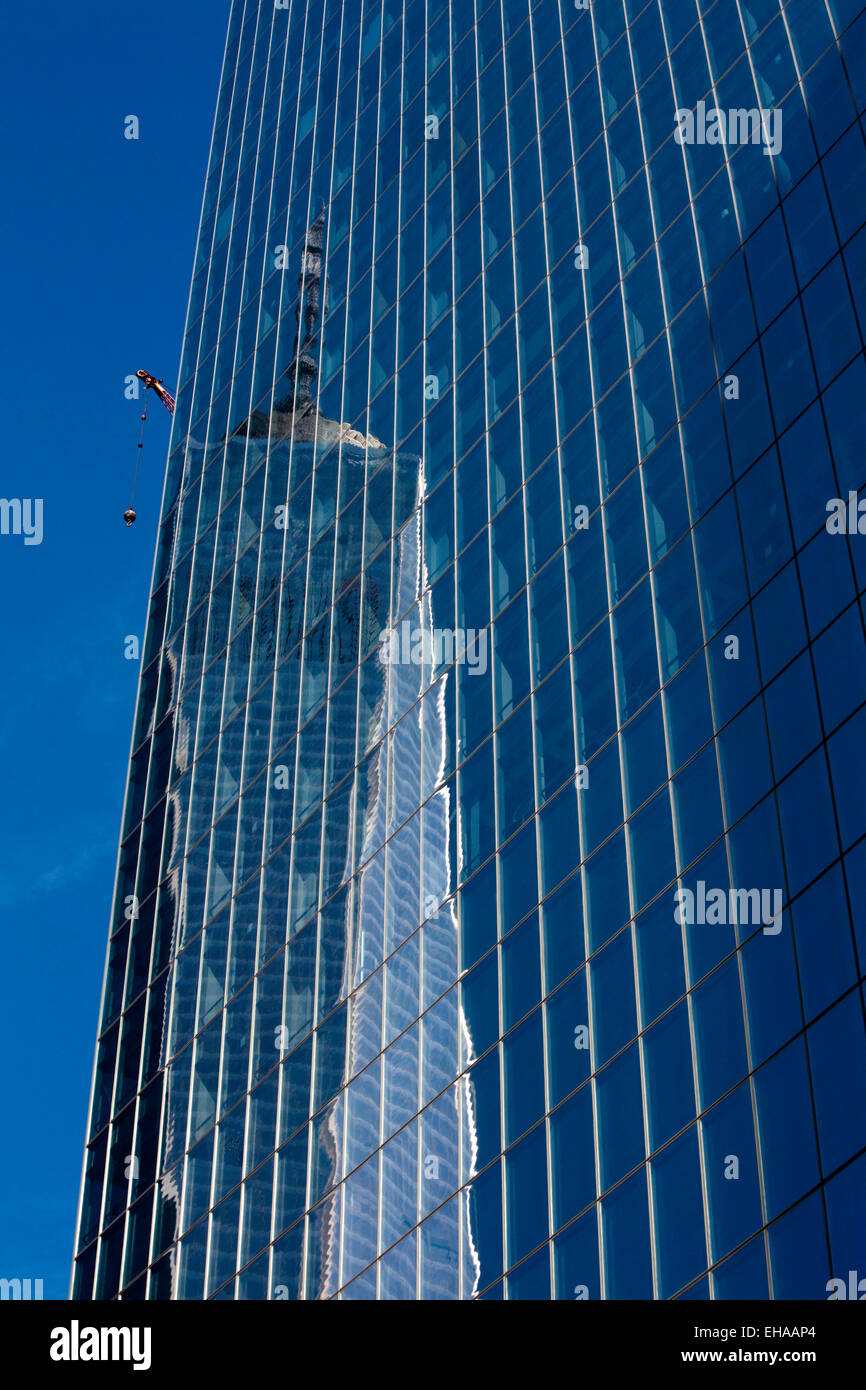 El One World Trade Center, La Torre de la libertad se refleja en el cristal de un edificio de oficinas del distrito financiero de la ciudad de Nueva York Foto de stock