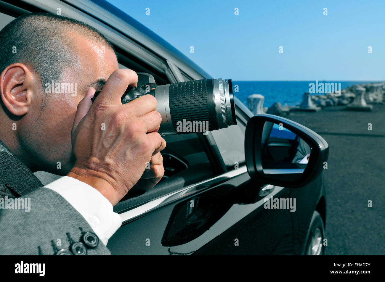 Un detective o un paparazzi tomando fotos desde dentro de un coche Foto de stock