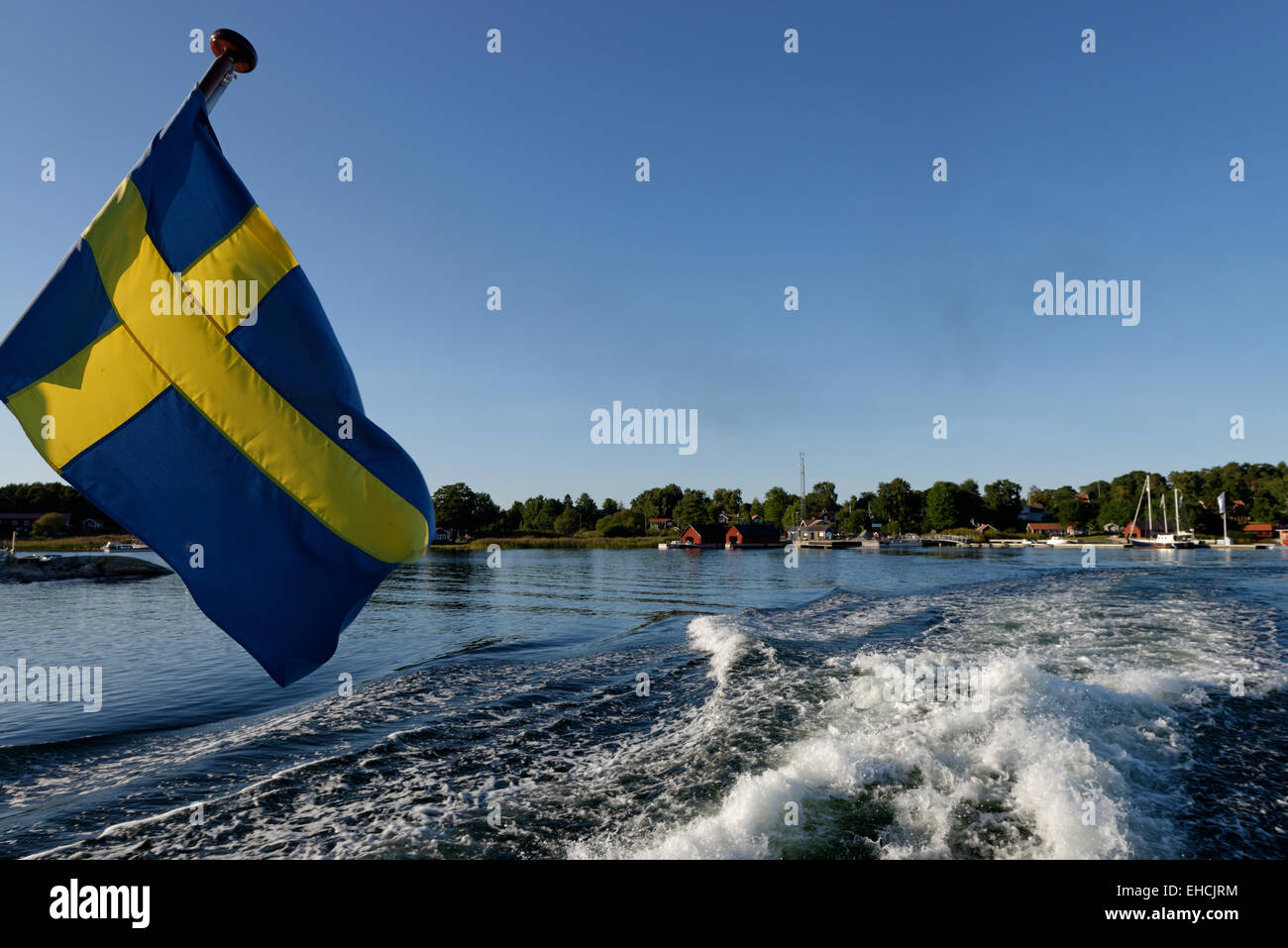 Barco con bandera sueca off Husarö, isla, en el municipio de Österåker, skärgård, archipiélago, Suecia Foto de stock