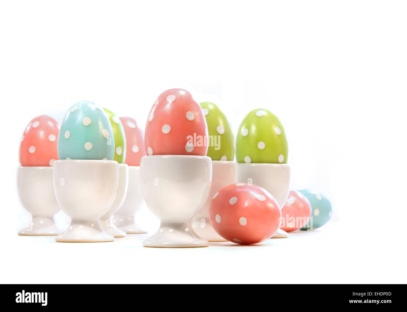 Huevos de pascua de lunares en tazas en blanco Foto de stock