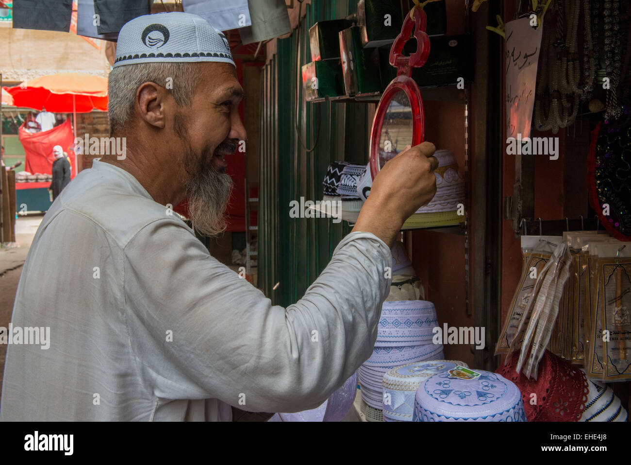 Viejo hombre tratando de Hotan, sombrero, musulmán, Domingo Bazar Foto de stock