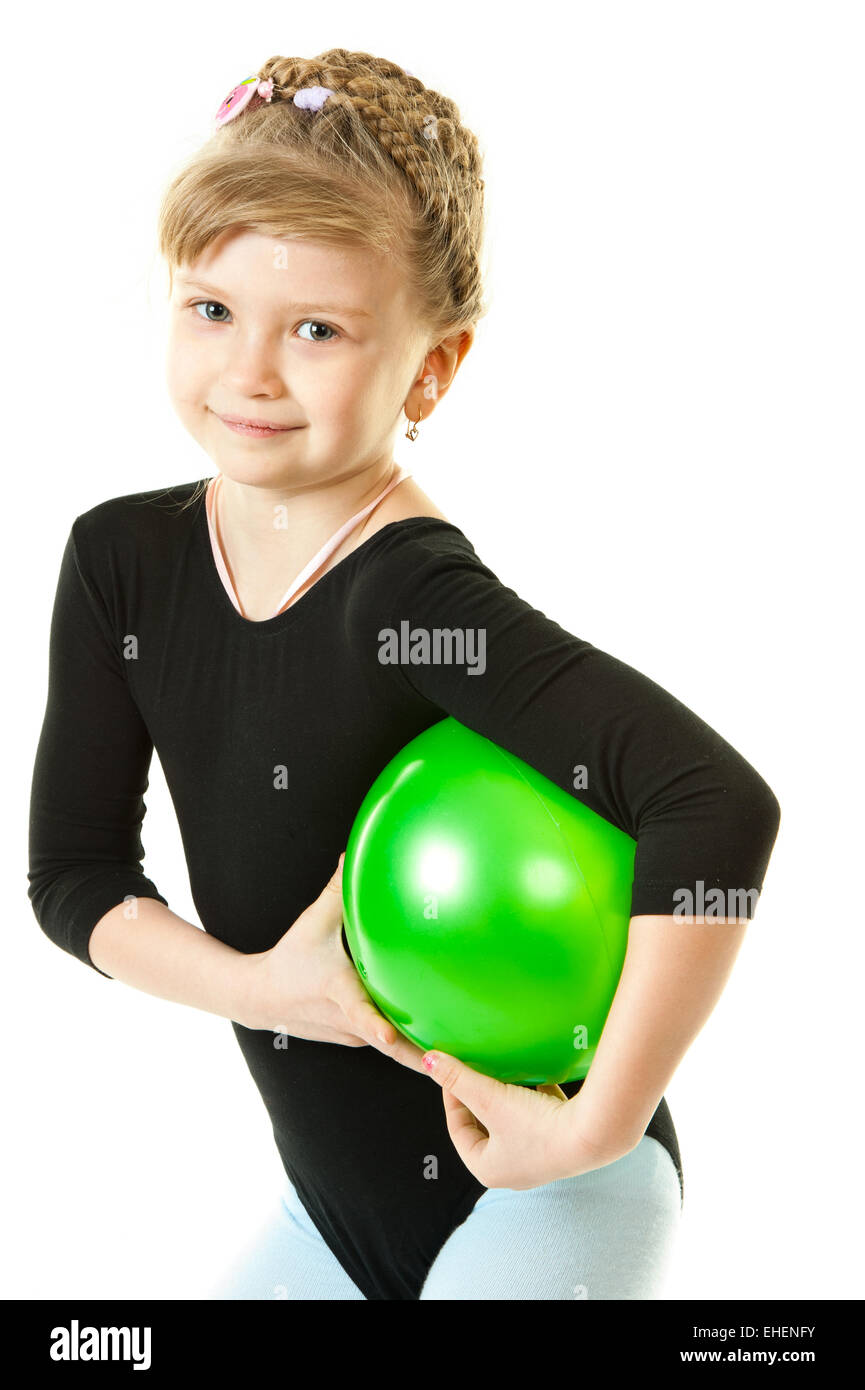 Una niña jugando con una bola verde Foto de stock