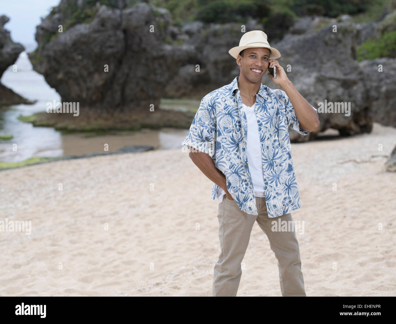 Hombre llamar / telefonea con Apple iphone 6 smartphone mientras en la playa. Foto de stock