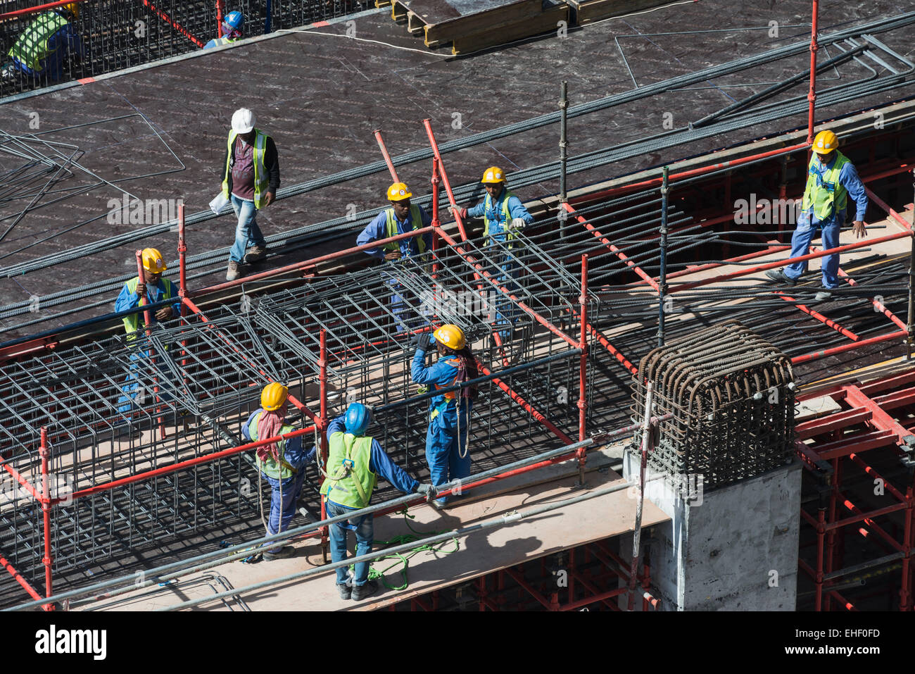 Los trabajadores migrantes en el sitio de construcción de apartamentos de gran altura de la torre de rascacielos en Dubai, Emiratos Árabes Unidos Foto de stock