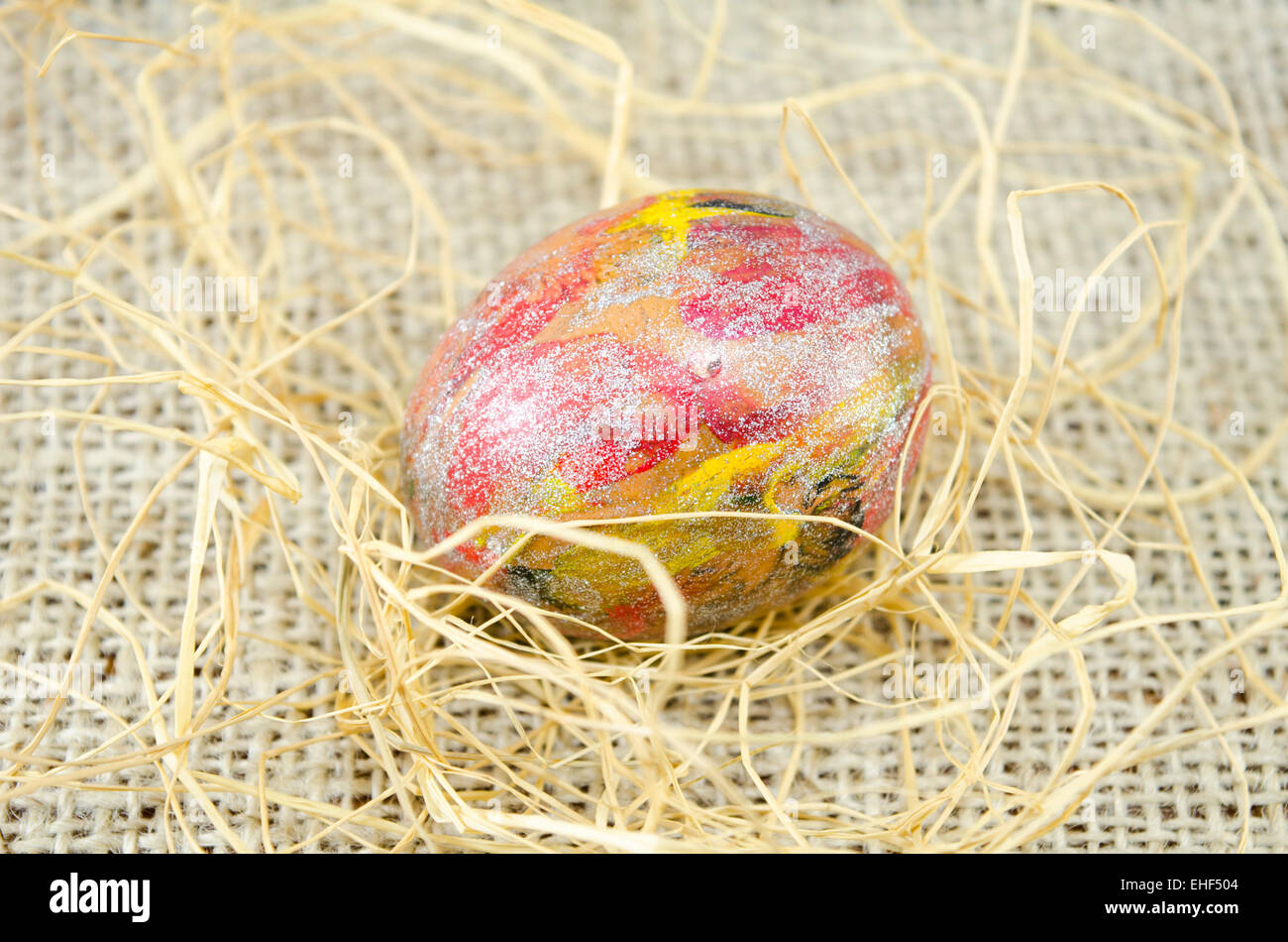 Huevo de Pascua pintados a mano y pajas en un mantel vintage Foto de stock