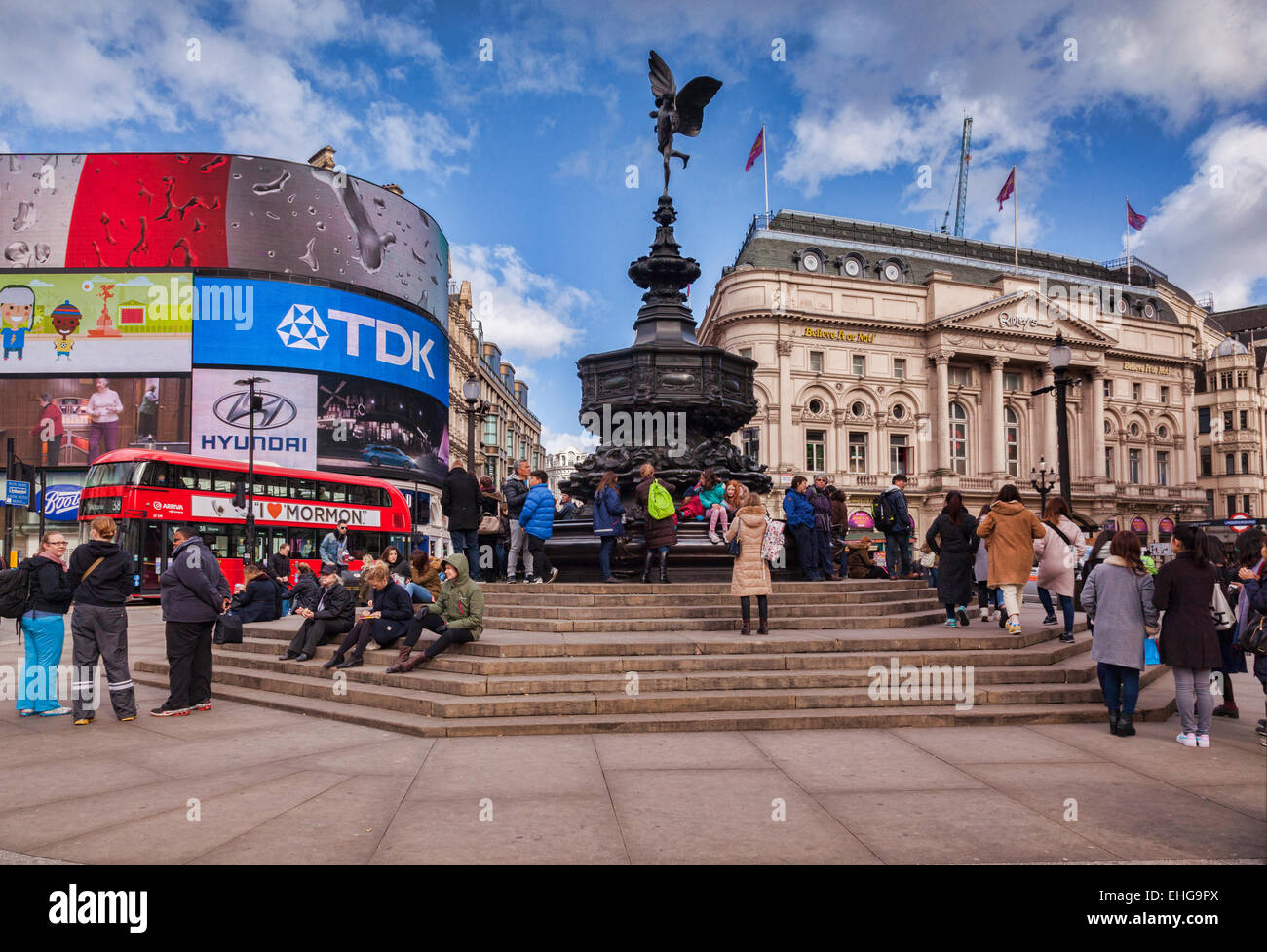 Piccadilly Circus, Londres, Inglaterra, con la estatua de Eros, multitudes de turistas y autobuses rojos de Londres, en un soleado día de invierno. Foto de stock
