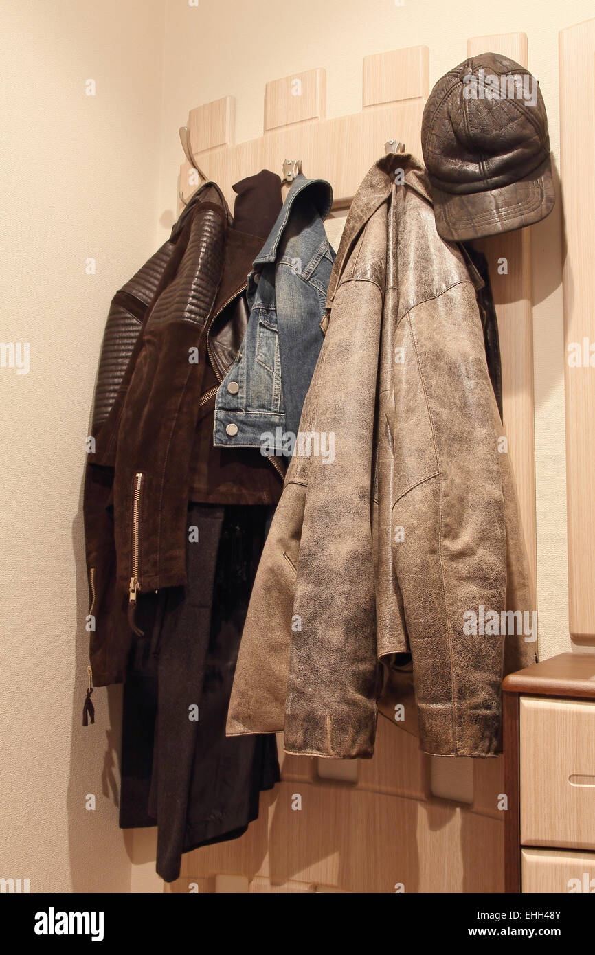 Varios ropa colgando de un perchero de madera. Foto de stock